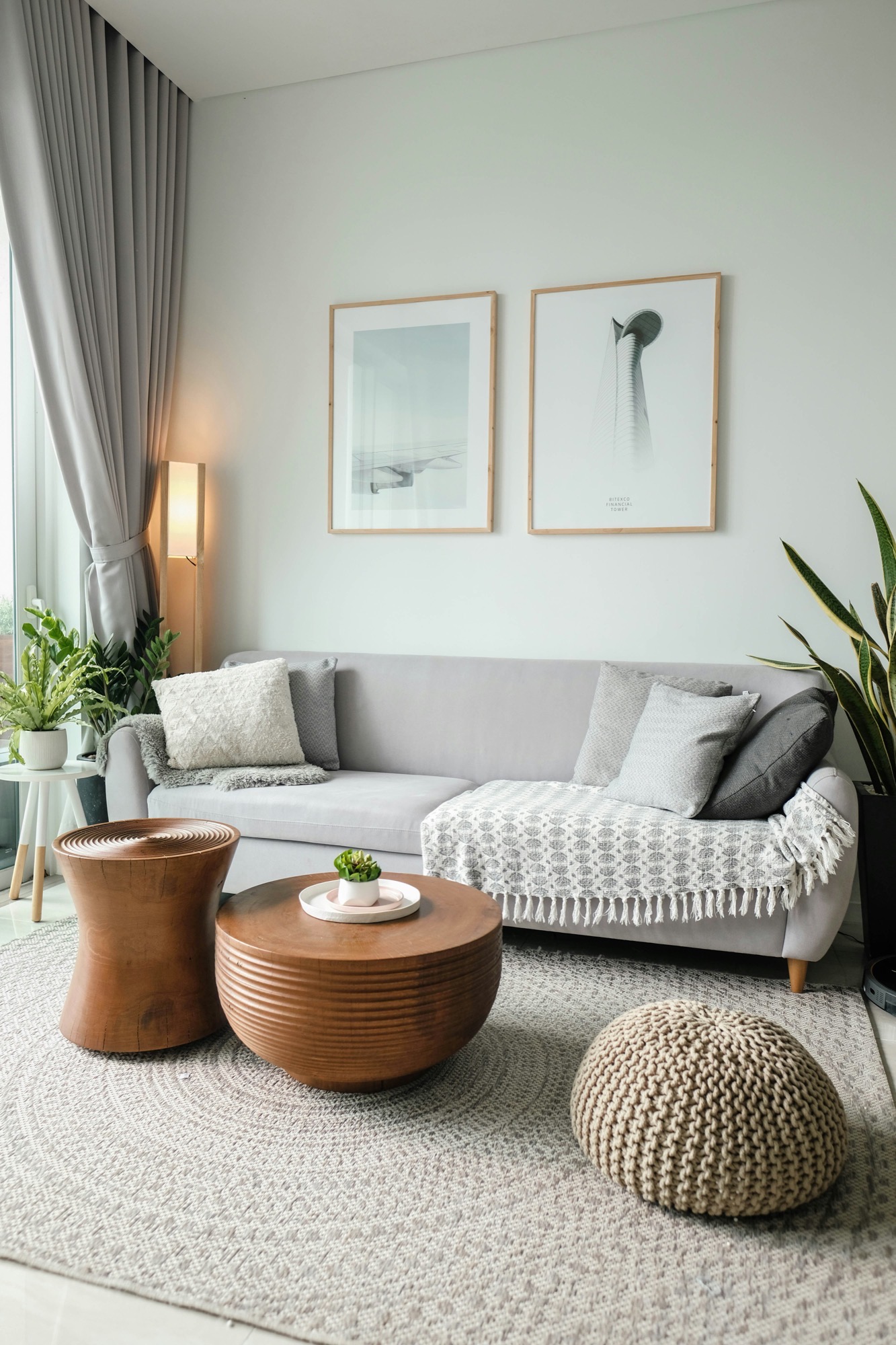 Bright, furnished living room with a neutral sofa, wood coffee tables, and natural light